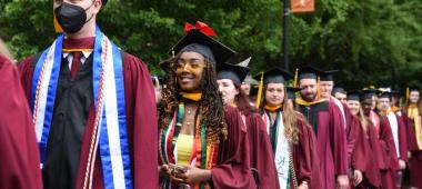 This is a photo of the Class of 2022 walking 和 smiling before commencement.