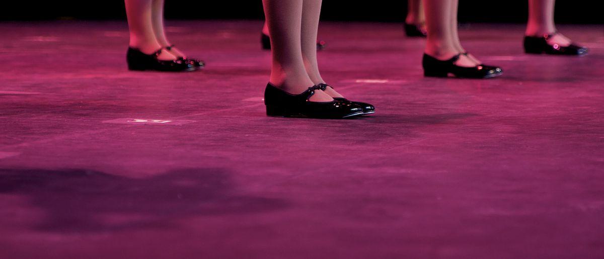 Dancers on stage during a recital in bright costumes. Noise reduction was applied on the floor and the dancers in the background but not ...