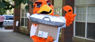 Benny the River Hawk helps first-year students move into their residence halls.